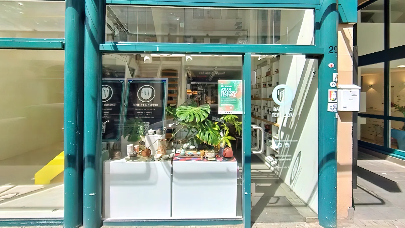 Bamboo Tea Room Geschäft grüner Fensterrahmen mit Pflanzen und Teeware Tür mit Hausnummer Schild mit „Cosy Tea Room“. Teeladen Köln Apostel-Viertel