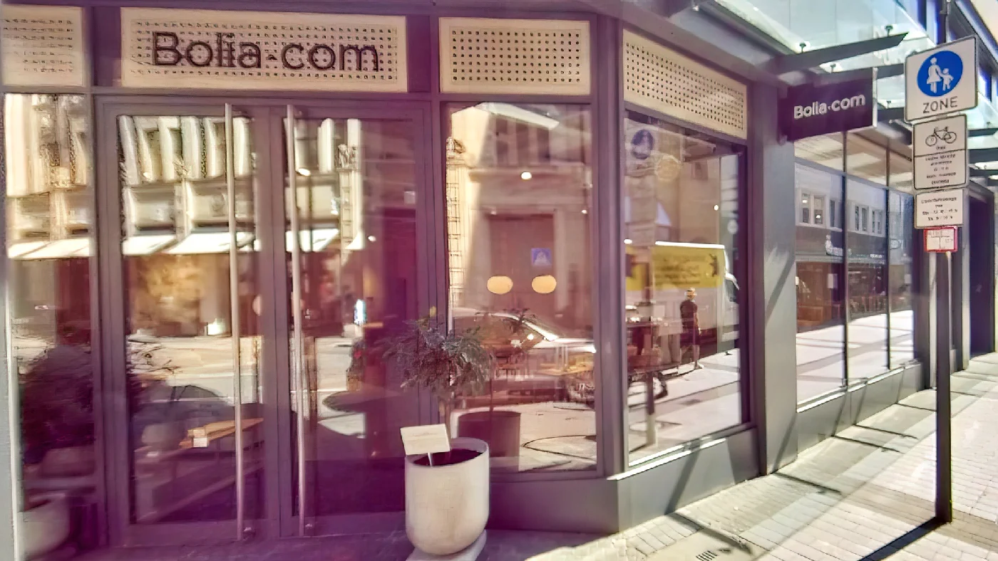Bolia.com Geschäft in Fußgängerzone mit gläserner Schaufensterfront Tür weißer Topfpflanze daneben Möbel Köln City