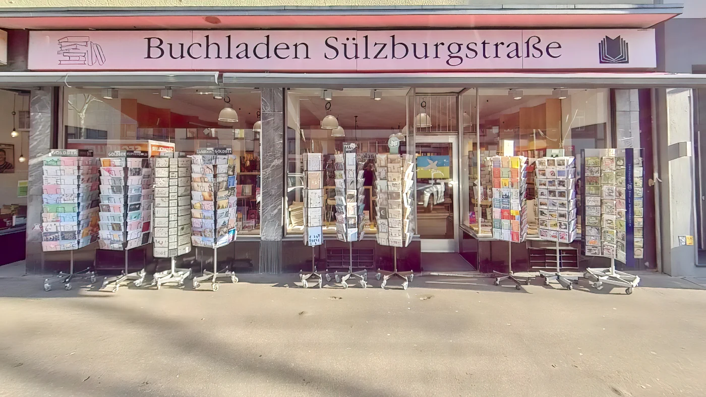 Buchladen Sülzburgstraße in Köln pinker Schriftzug über Eingang zwei große Fenster Bücherregale mit Büchern davor Buchhandlung Köln Sülz