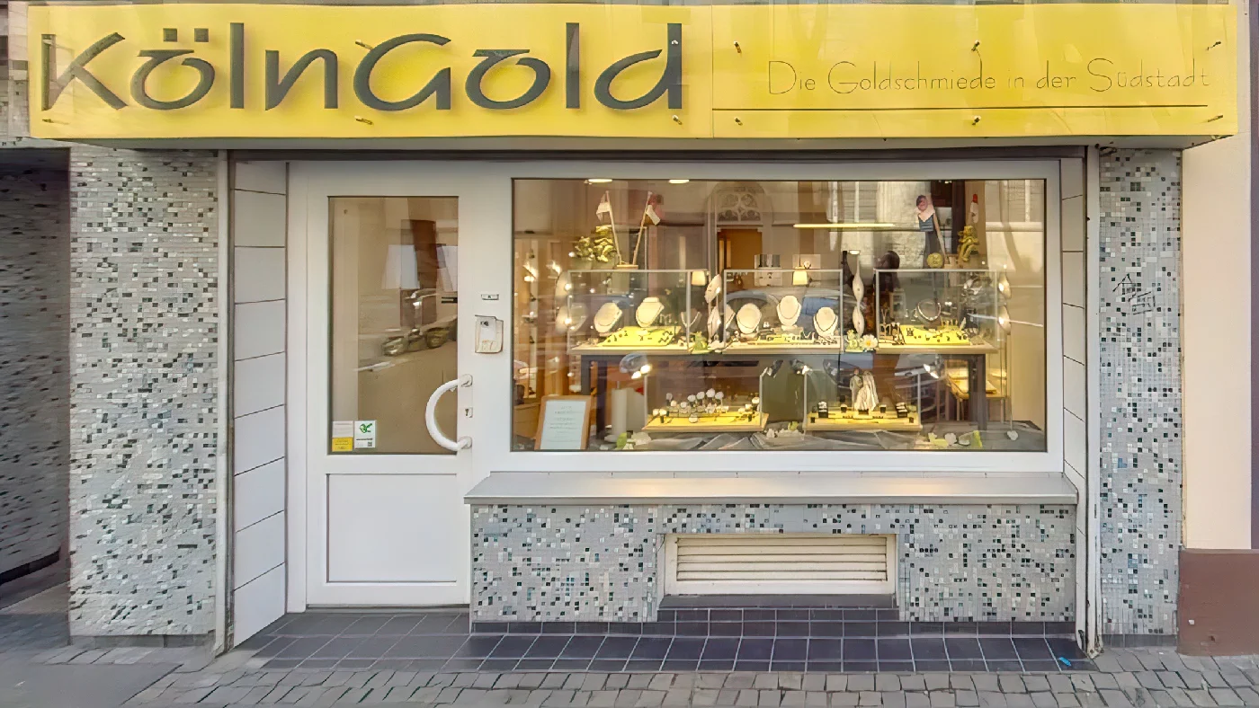 Goldschmiede Köln Gold mit gelbem Schild und Schaufenster-Auslage an Geschäftsfront. Goldschmied Köln Severins-Viertel