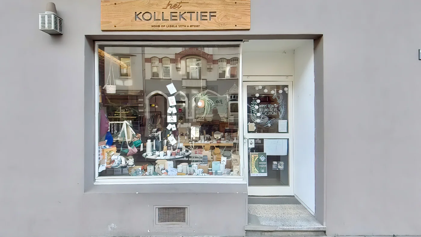 het KOLLEKTIEF Geschäft Köln Schaufenster mit Taschen Schmuck Holzschild über Eingang Kamera links. Boutique Köln Sülz