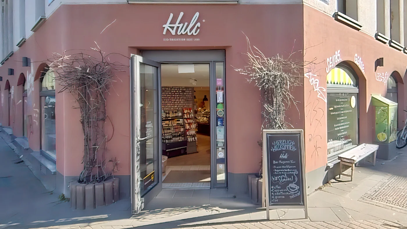 HULC Bio-Food Ladenfront rosa Wände großes Schaufenster Speisekarte Pflanzenkübel Backsteinbürgersteig andere Geschäfte Bioladen Köln Belgisches Viertel