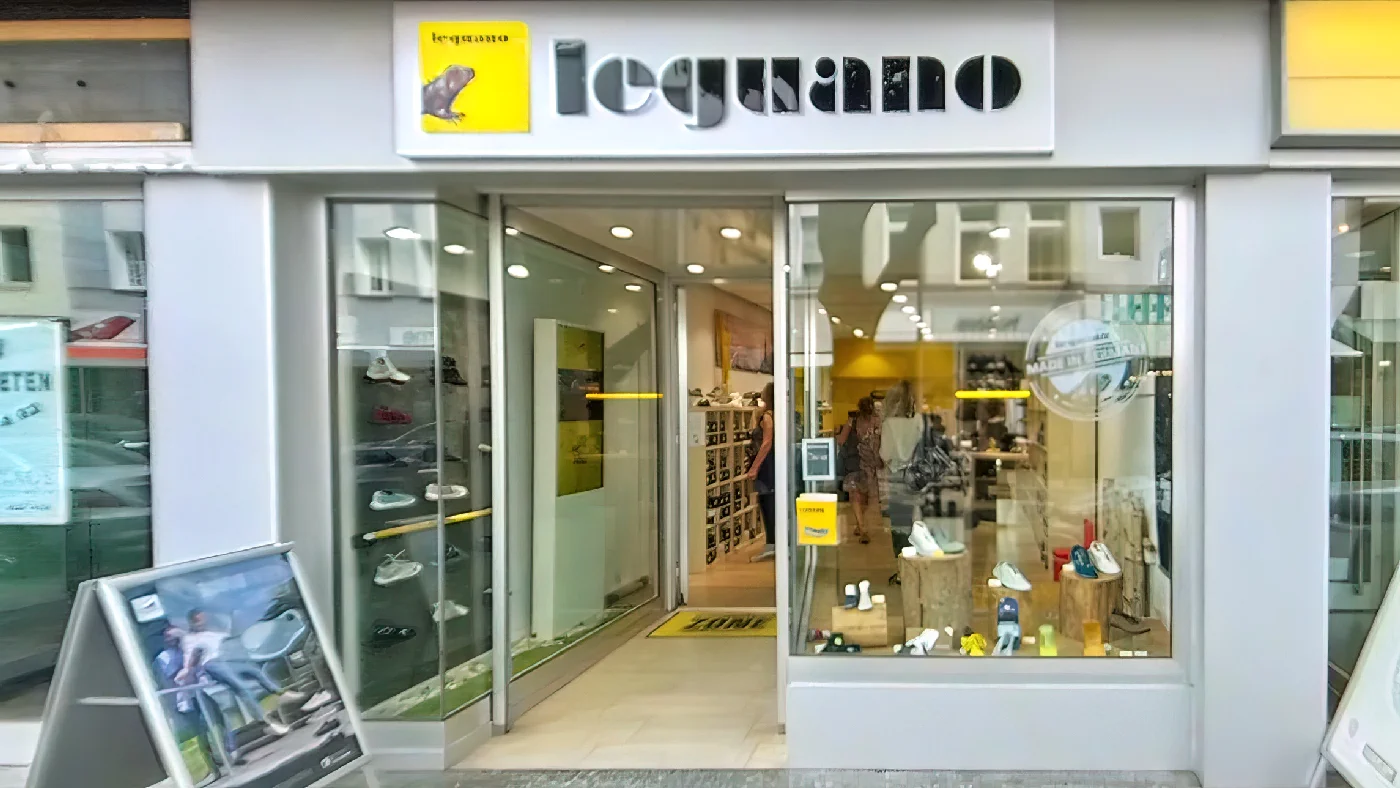 Geschäft leguano Barfußschuhe in Köln gelbes Schild über Fenster graue Fassade Schaufenster mit Schuhen Straßenszene im Hintergrund Schuhe Köln Apostel-Viertel