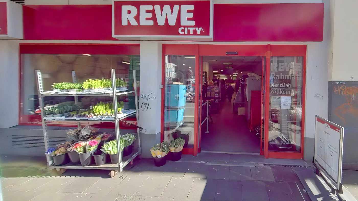 REWE Rahmati Brüsseler Straße mit rotem Vordach Blumen und "Herzlich willkommen" Schild Supermarkt Köln Belgisches Viertel