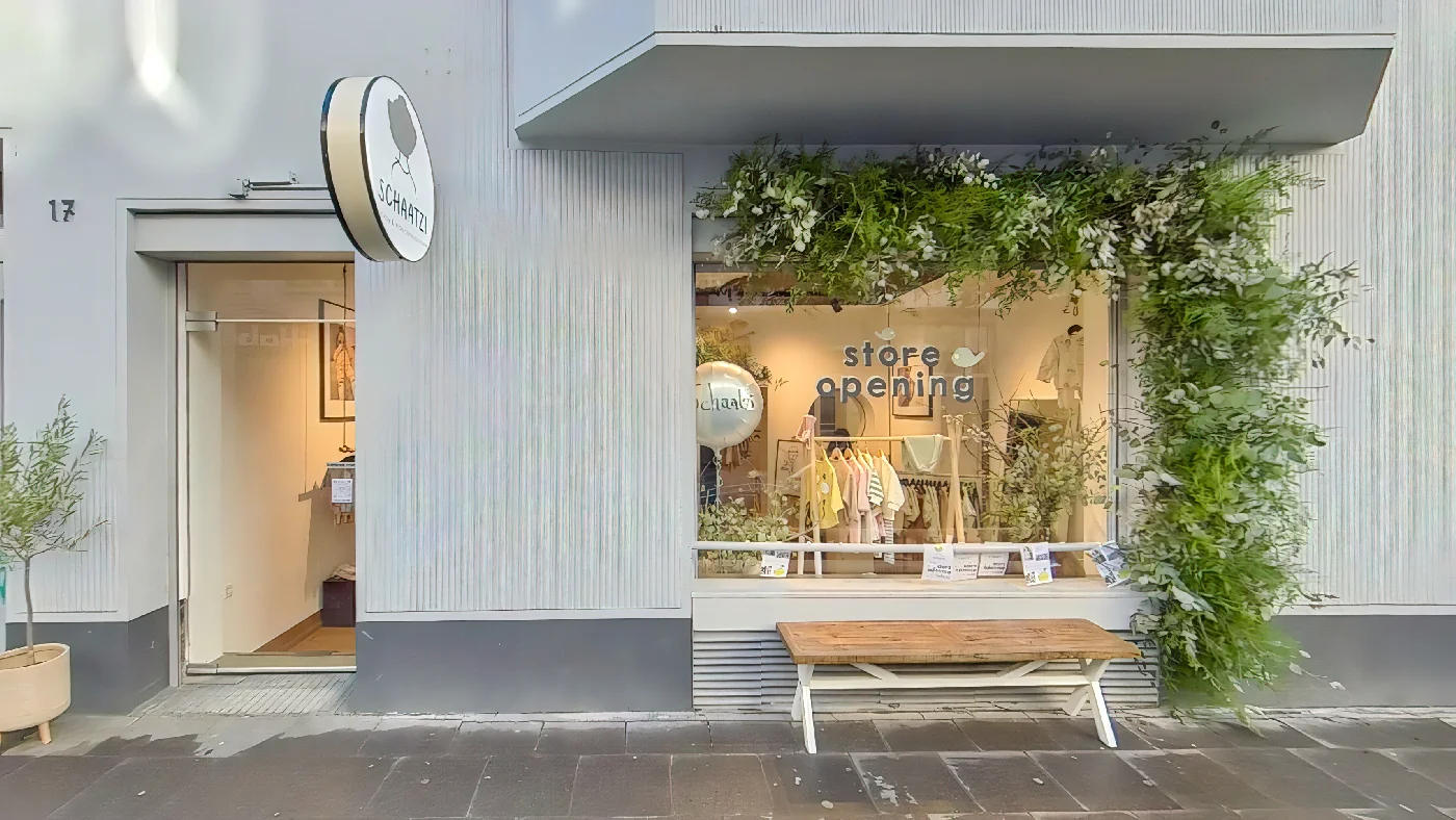 Schaatzi Bekleidungsgeschäft mit grauem Vordach rundem Logo und "Store Opening" Schriftzug Bekleidungsgeschäft Köln Belgisches Viertel