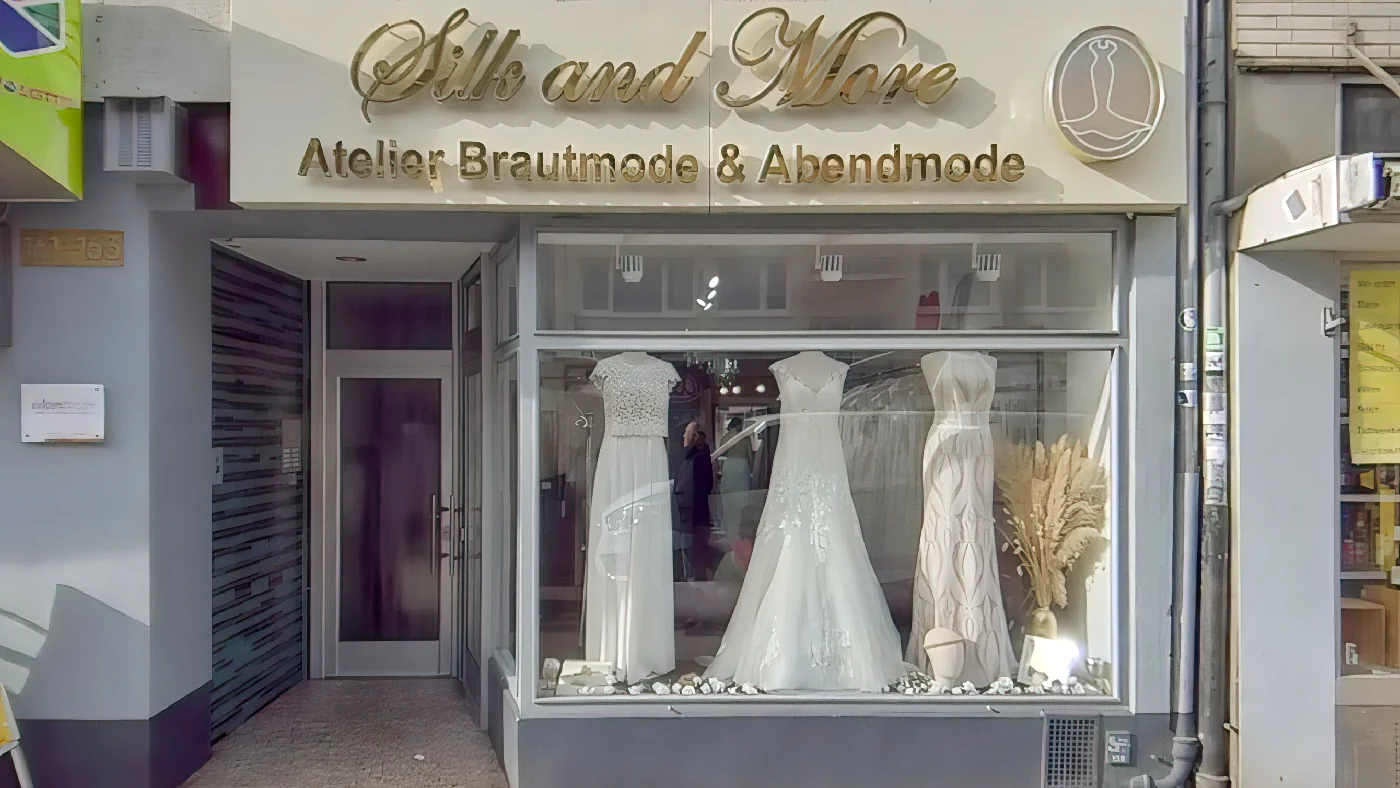 Silk and More Brautmoden-Boutique mit Brautkleidern im Schaufenster und goldenem Logo-Schild Brautmode Köln Severins-Viertel