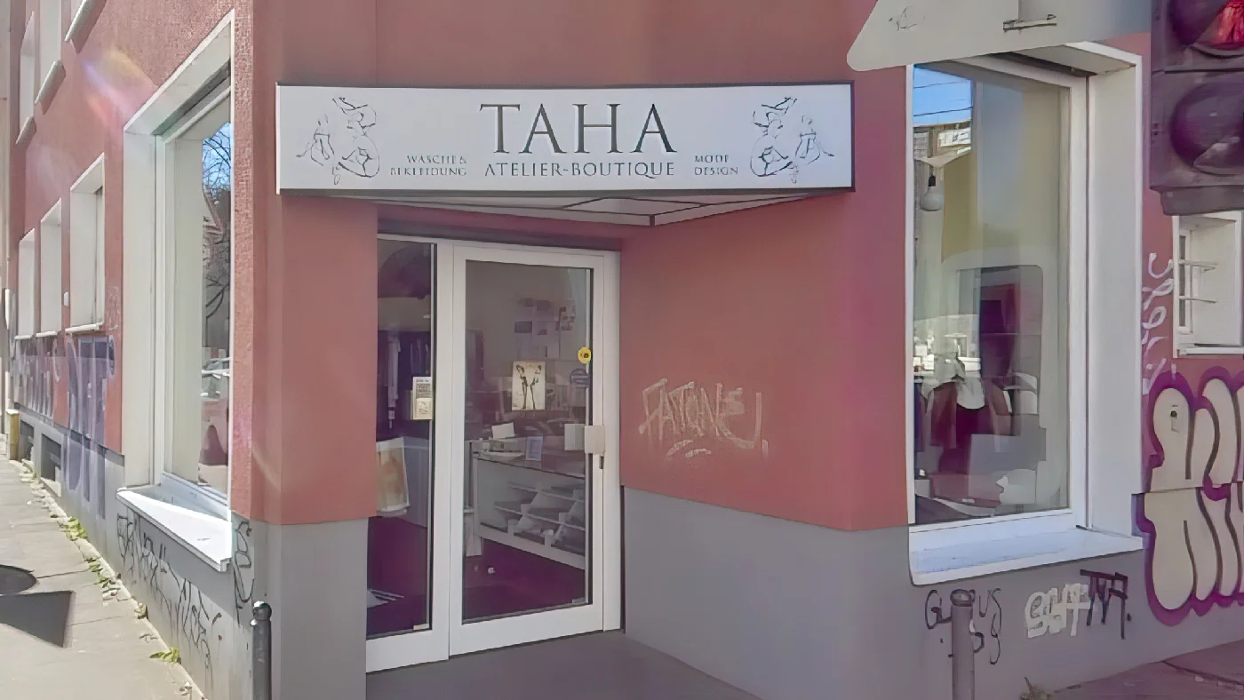 TAHA Mode-Design Geschäft mit rosa-weißer Fassade und Atelier-Schriftzug Schneider Köln Belgisches Viertel