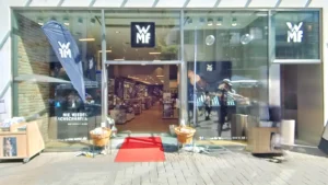 WMF Köln Schildergasse blaue Flaggen roter Teppich am Eingang. Fachhandel für Küchenbedarf Köln Neumarkt-/Cäcilien-Viertel