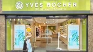 Yves Rocher Geschäft in Dunkelgrün weiße Beschriftung Pflanzen sonniger blauer Himmel. Kosmetik Köln City